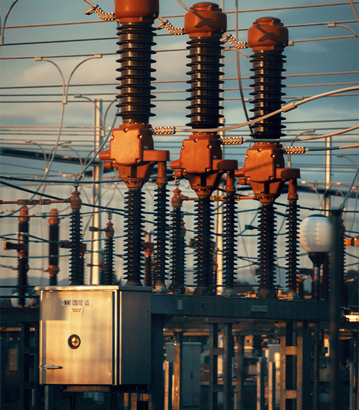 Subestación eléctrica con aisladores de alta tensión y gabinete metálico